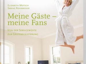 Buch von Elisabeth Motsch "Meine Gäste - meine Fans" Man sieht eine Frau, die auf dem Bett springt. Es ist in einem Hotelzimmer. Der Koffer steht in der Ecke