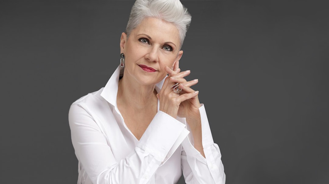 Das ist Elisabeth Motsch, sie ist bei einem Fotoshooting mit dem Tiroler Goldschmied in Meran. Als Schmuckexpertin berät sie namhafte Juweliere, damit sie ihre Kunden mit Schmuckwissen noch besser beraten können. So auch den Tiroler Goldschmied. Alle Mitarbeiter sind von ihr geschult. Sie zeigt in ihren Seminaren, wie man eine Resonanz zwischen der Person un dem Schmuck schafft. Sie hat weißes Haar, trägt eine weiße Bluse, dazu sehr schönen Schmuck in Weißgold mit Steinen in einem außergewöhnlichen Design. Der Schmuck ist perfekt auf sie abgestimmt und wirkt sehr resonant zu ihr.